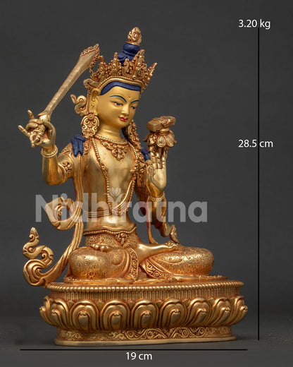 Manjushri statue side view holding flaming sword and utpala flower with sacred sutra.