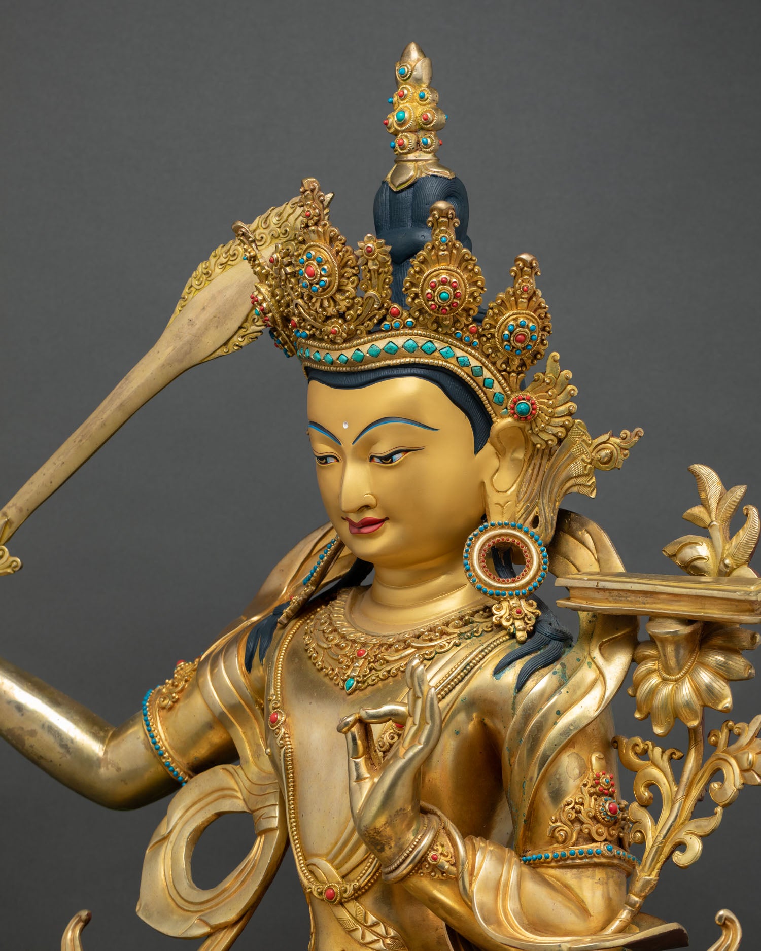 Manjushri statue upper body, sword and blossoming lotus flower detail