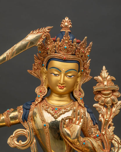 Manjushri statue with 24k gold painted face and semi precious stone adornment.