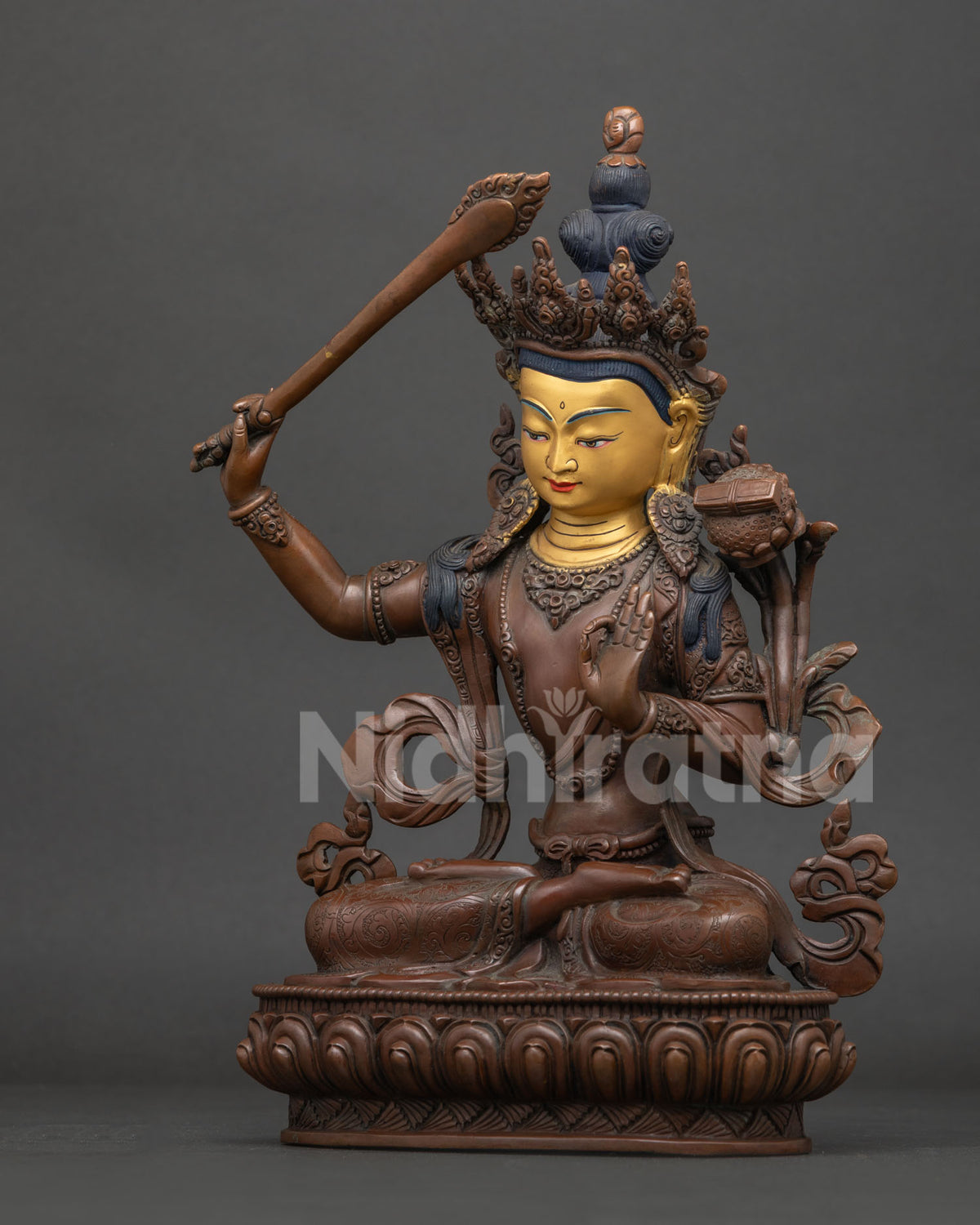 Manjushri bodhisattva statue showing sword of wisdom and blooming lotus stem.