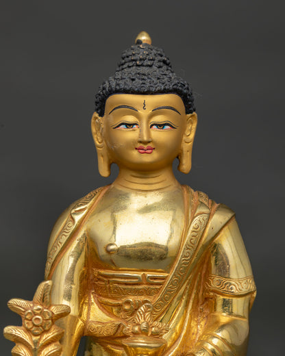 Medicine buddha bhaisajyaguru face with gold painted details and serene expression.