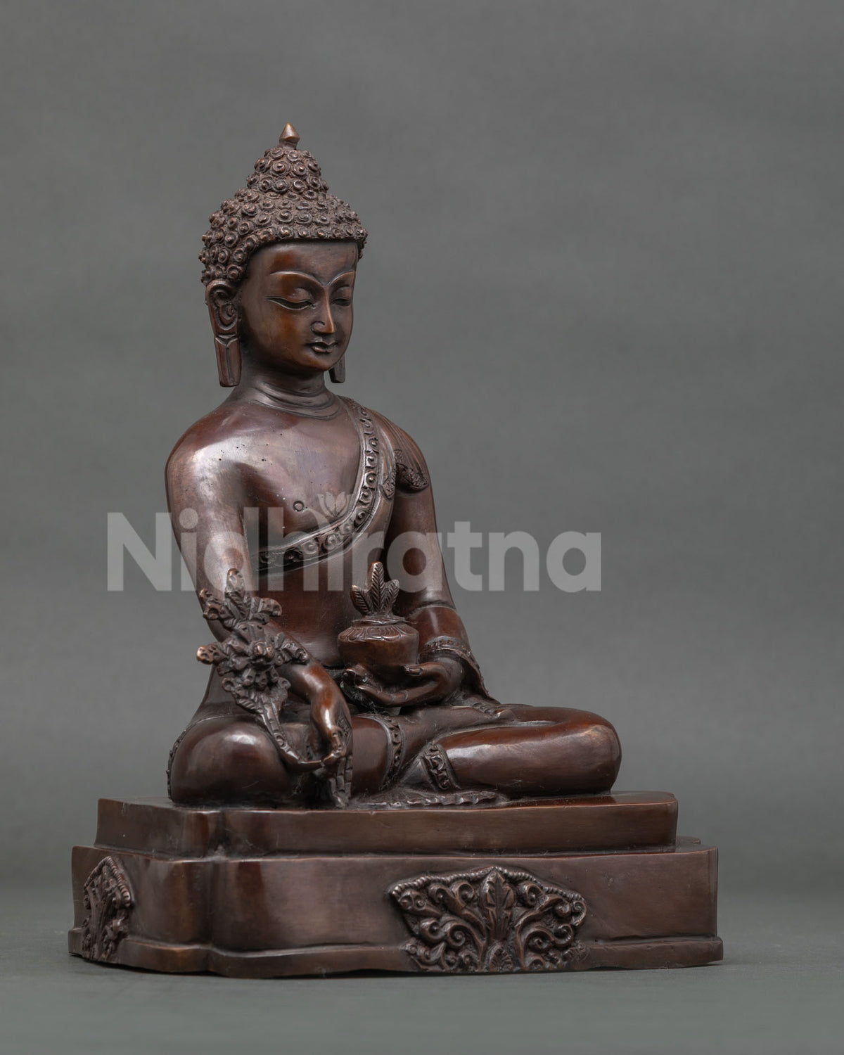 Medicine buddha bhaisajyaguru statue holding healing nectar bowl.