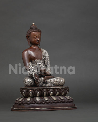 Medicine buddha bhaisajyaguru statue with serene expression and silver plated monk robe.