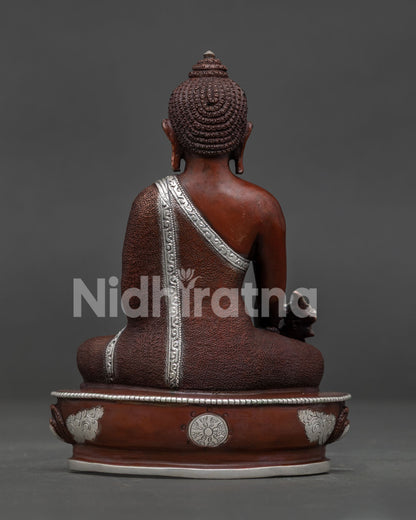 Medicine Buddha Buddhist statue on lotus pedestal with oxidized copper finish.
