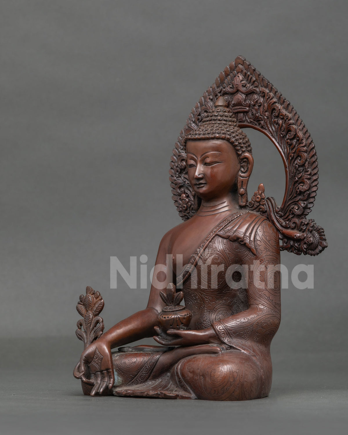Medicine Buddha sculpture holding a myrobalan plant and medicine bowl filled with healing nectar