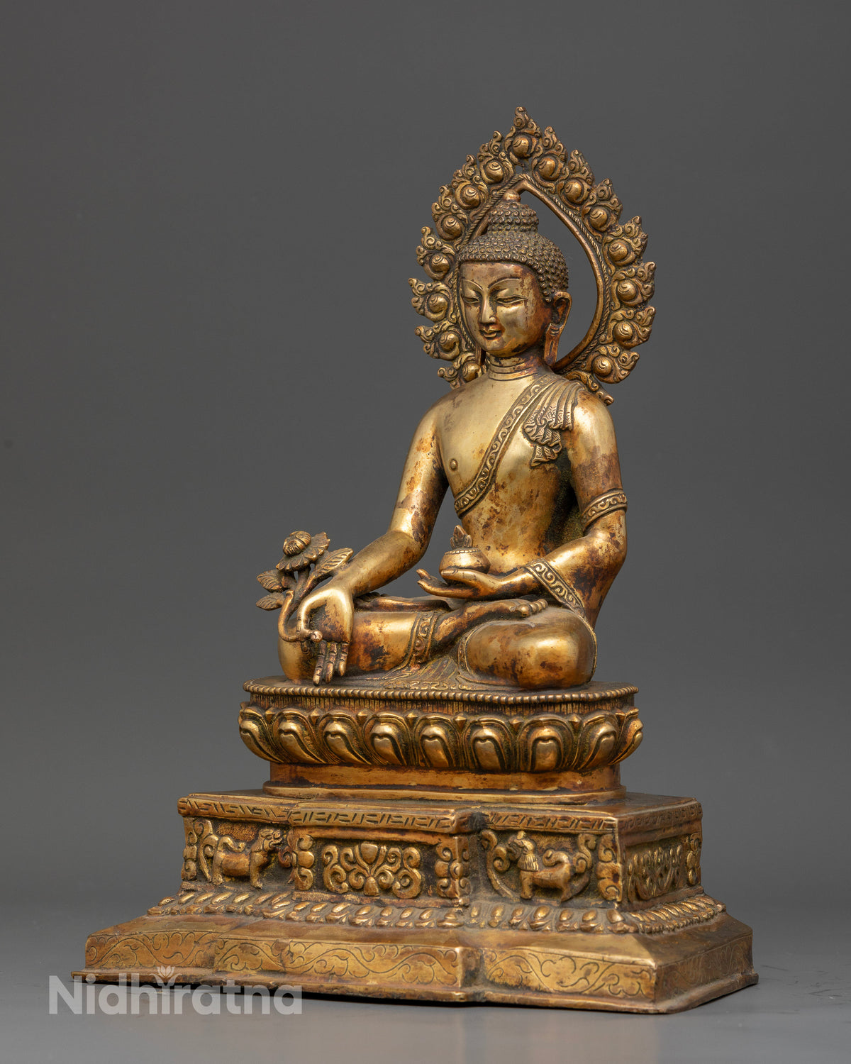 Medicine buddha seated on celestial throne with snow lion engravings.