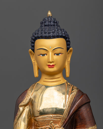 Medicine Buddha statue close up 24K gold painted face healing nectar bowl myrobalan plant details.