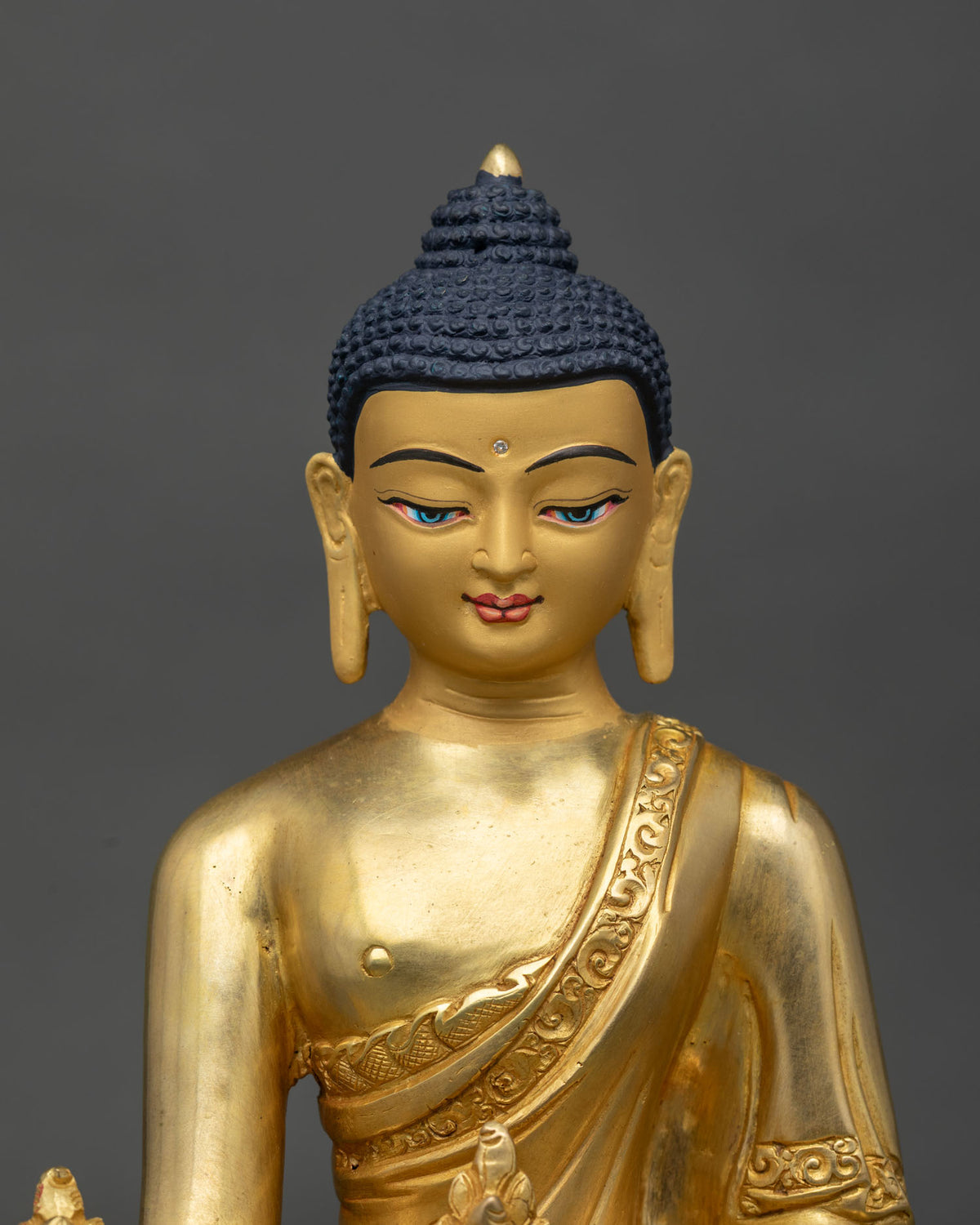 Medicine Buddha Statue close-up, copper gold gilded sculpture showing fine detail