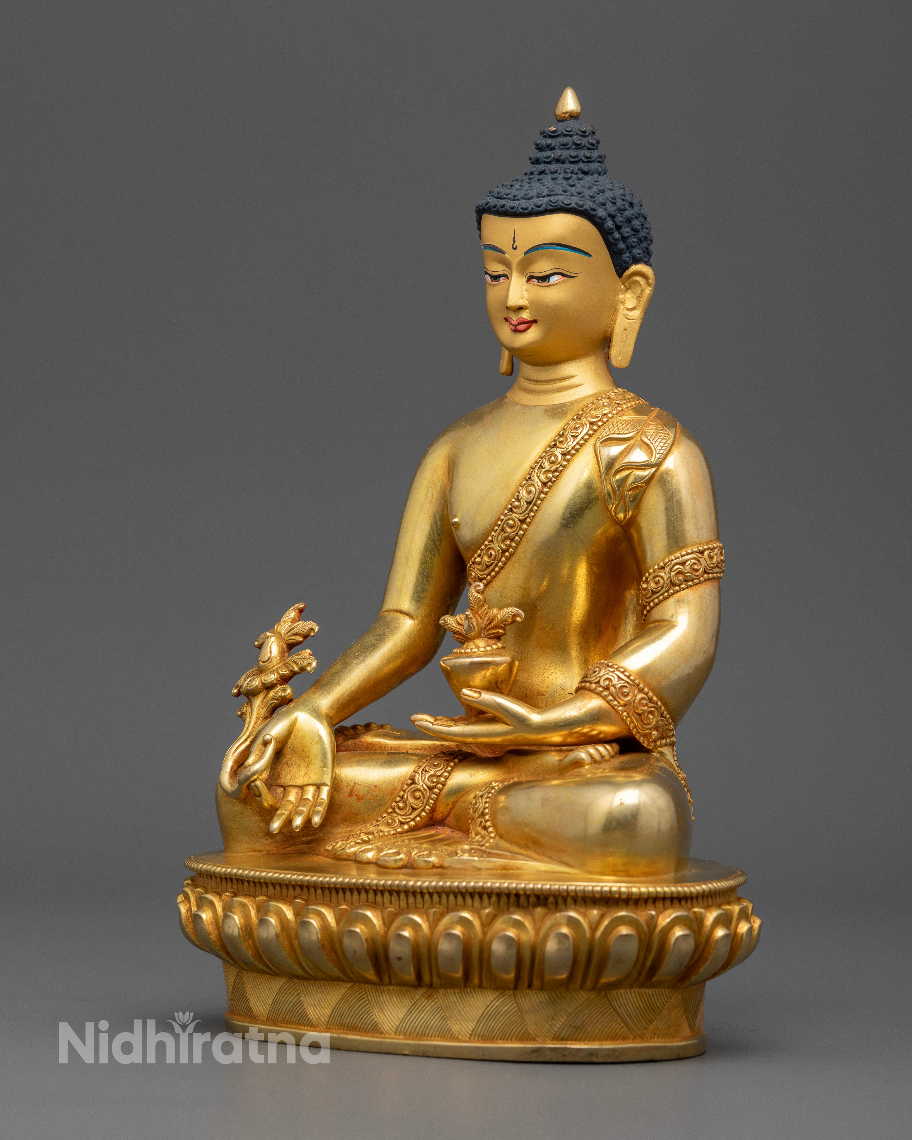Medicine buddha statue holding healing nectar bowl and sacred myrobalan plant.