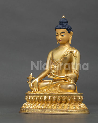 Medicine Buddha statue monastic robe gold fire gilded details.