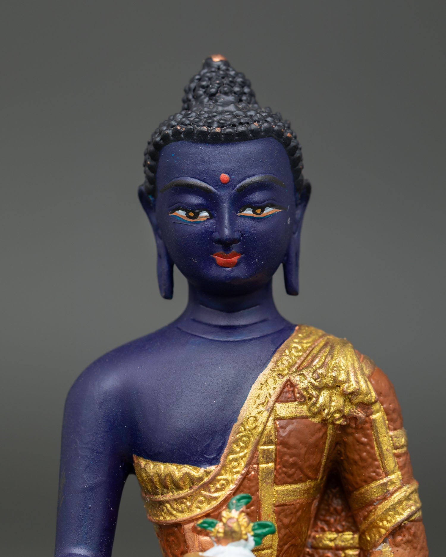 Medicine buddha statue showing gold details and healing nectar bowl.