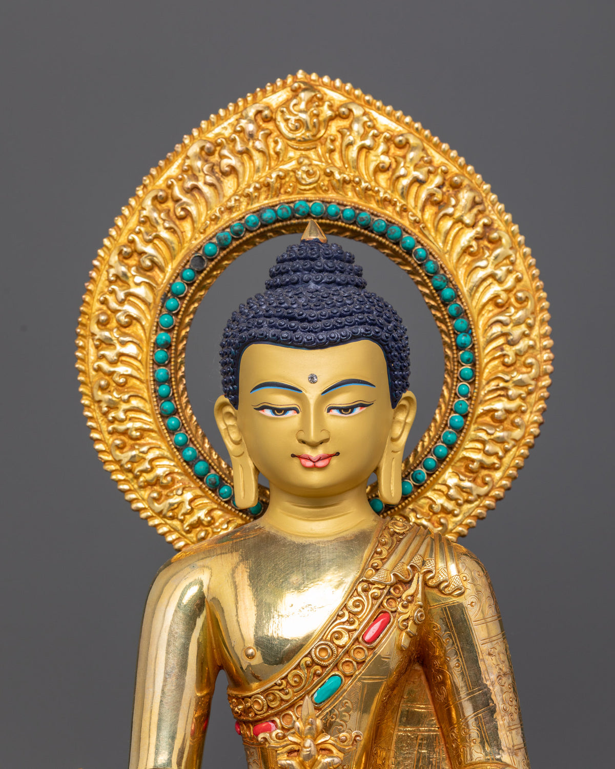 Medicine Buddha statue with a 24K gold-painted face, semi-precious stones, and an intricately carved halo.