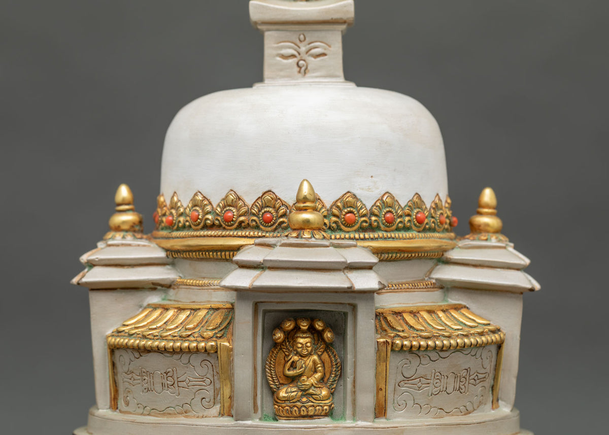 Meditating Buddha carved in a niche of a hand-painted Nepali stupa with semi-precious adornments