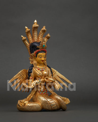 Naga Kanya serpent goddess statue holding a conch shell in graceful pose.