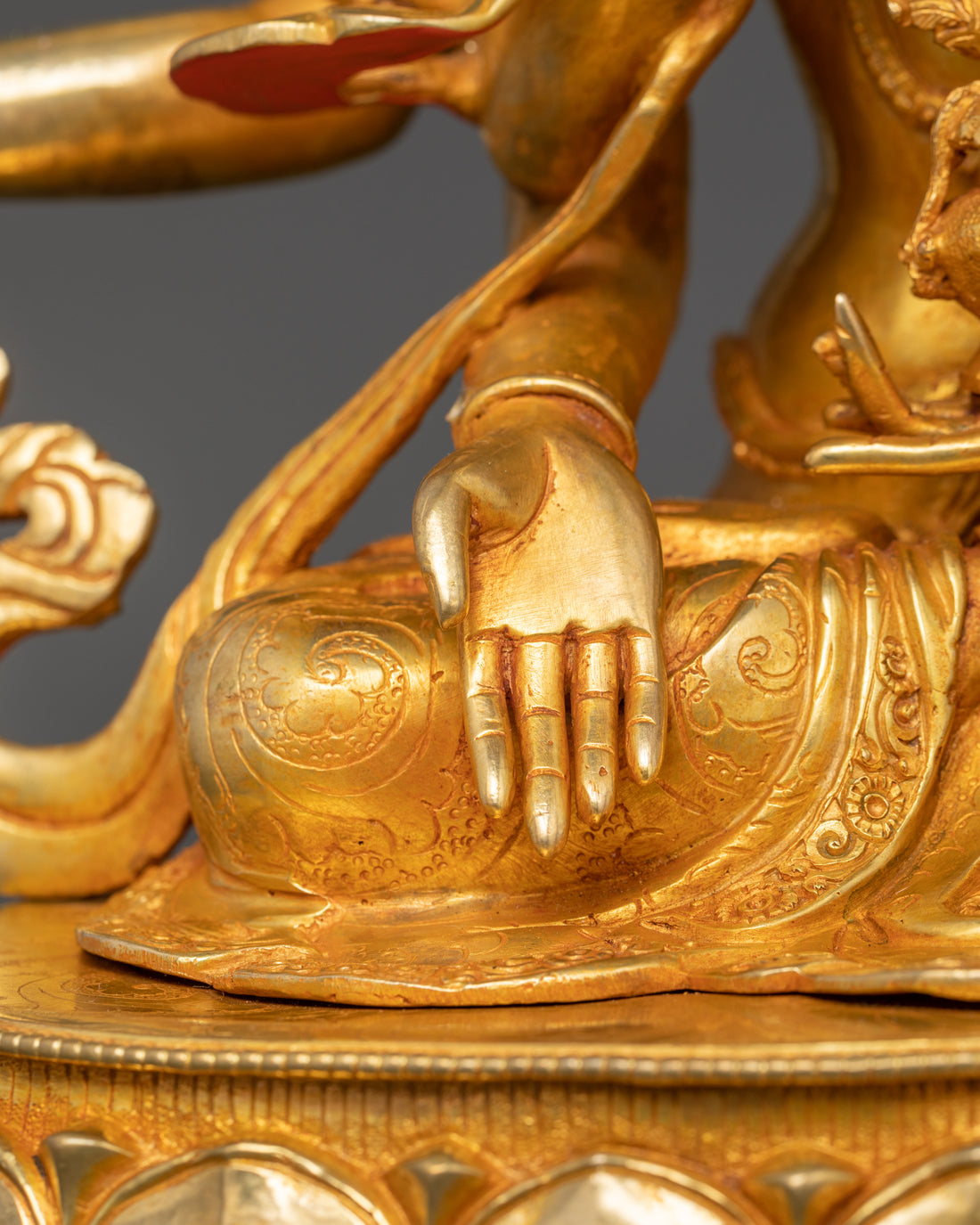 one of the arms of namgyalma statue resting on the leg