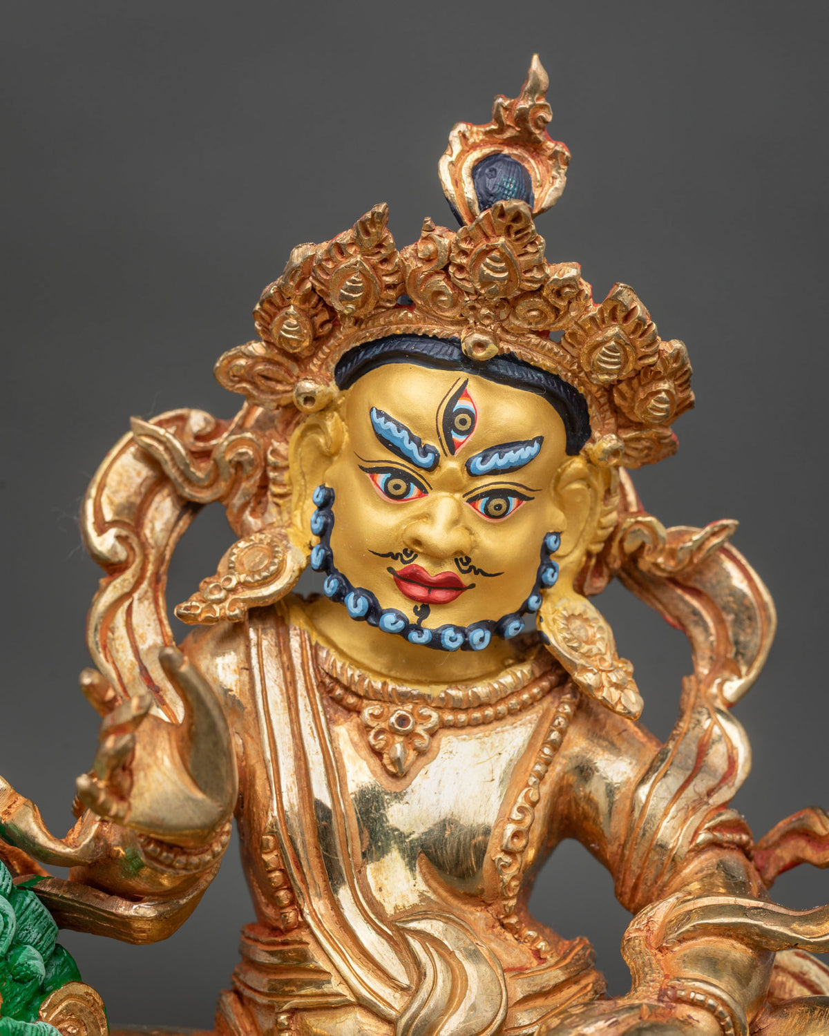Namtoshe Statue close up 24K gold painted face victory banner jewel spouting mongoose.