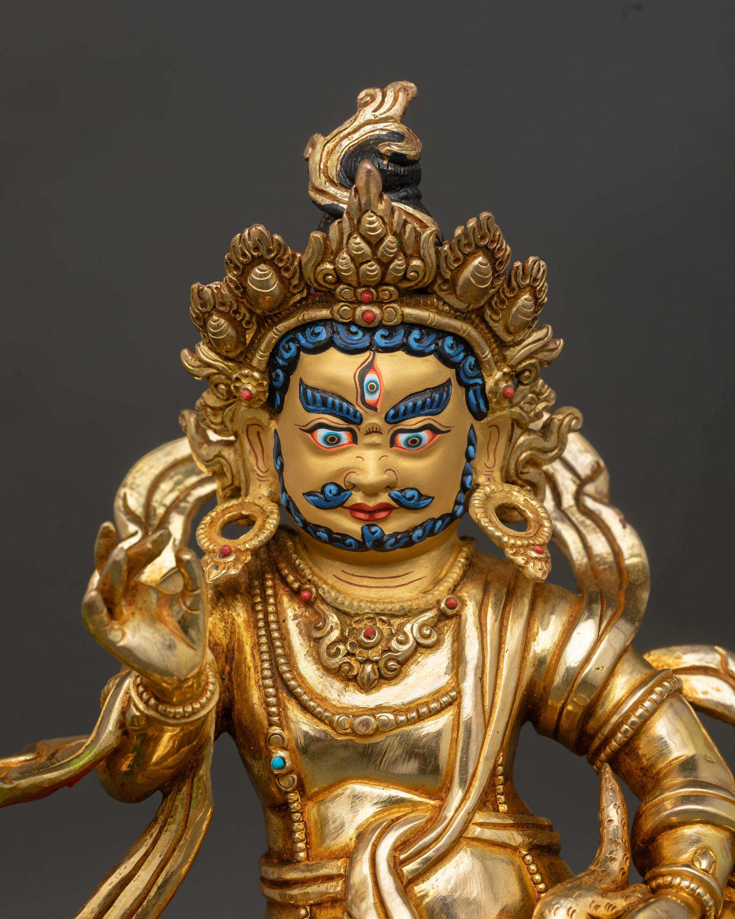 Namtoshe statue close up gold painted face flaming halo semi precious stones detail spiritual art