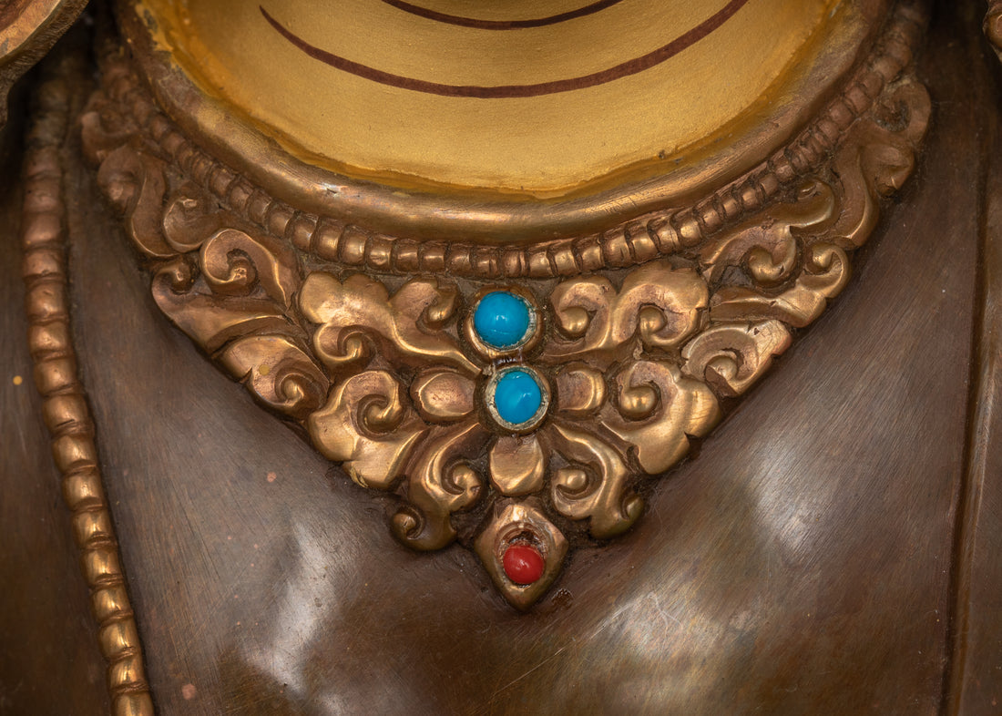 necklace of green tara statue is adorned with blue turquoise and red coral