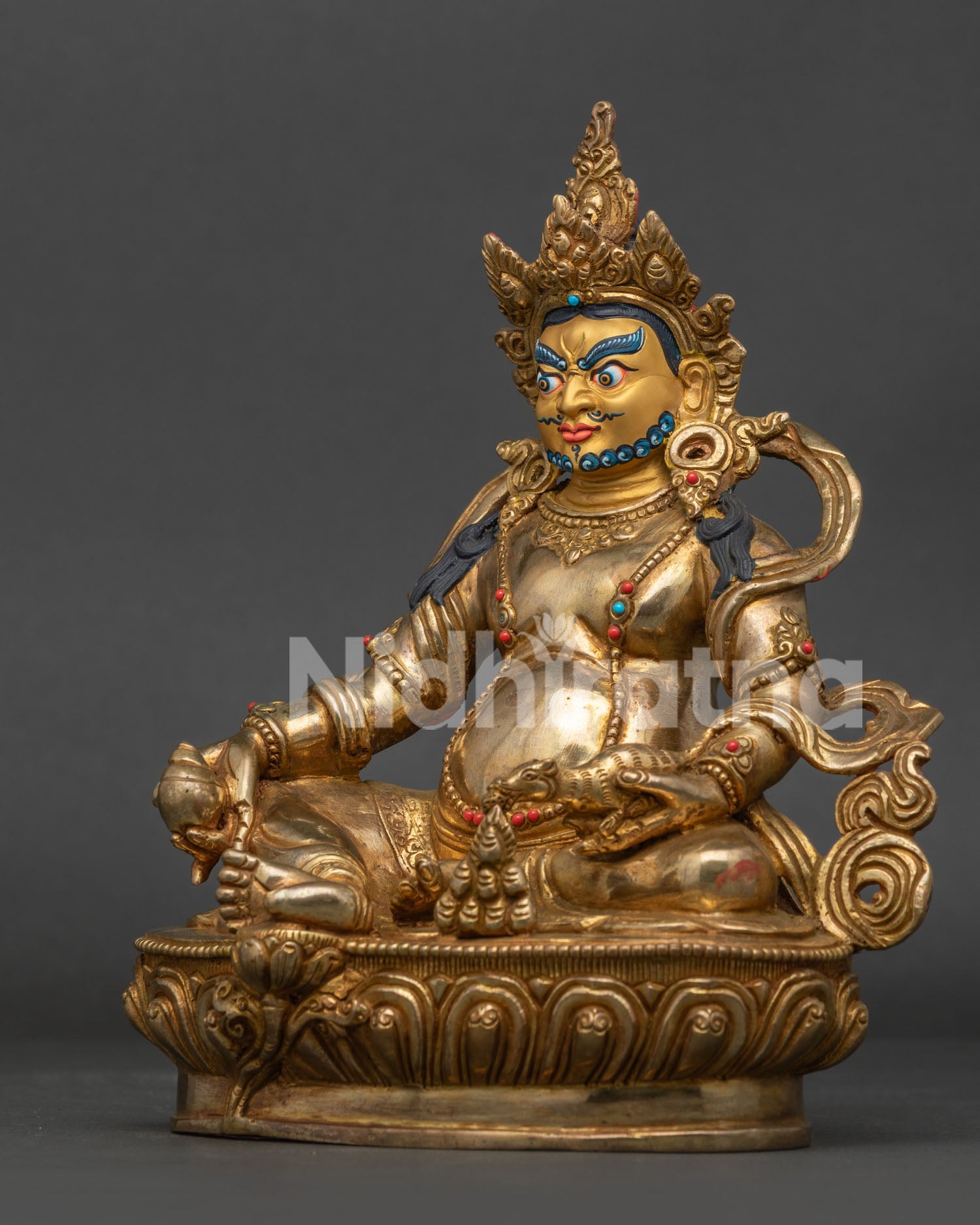 Nepalese Dzambhala statue side view with extended leg resting on conch shell.