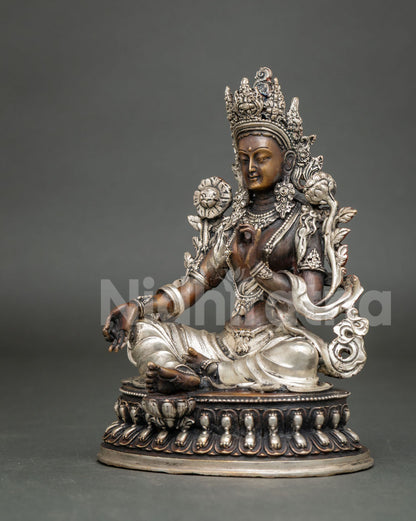 Opposite three-quarter view of Green Tara meditation statue with brown patina and silver accents