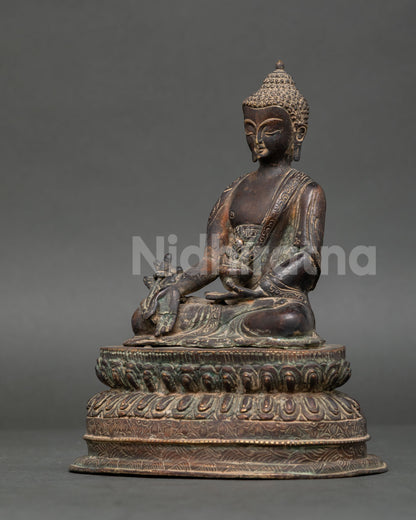 Oxidized Copper Medicine Buddha holding myrobalan plant and medicine bowl.