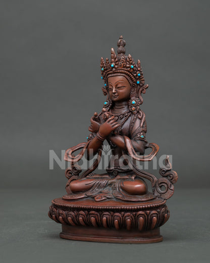Oxidized Vajradhara statue seated in vajraparyanka posture on detailed lotus pedestal.