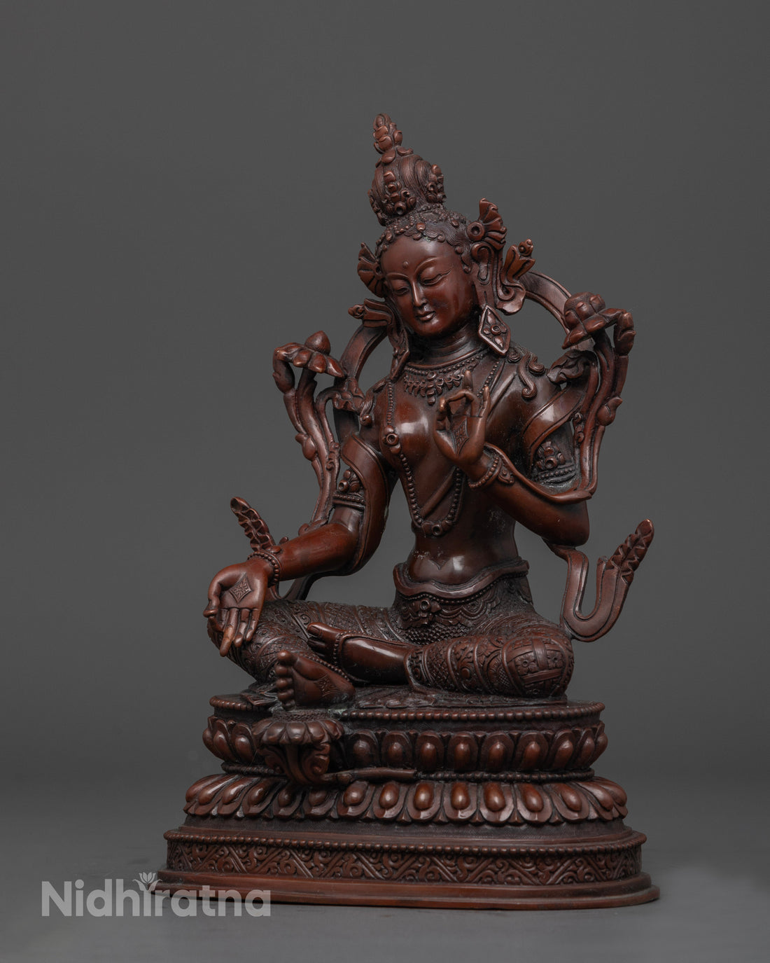 side view of oxidized statue of green tara