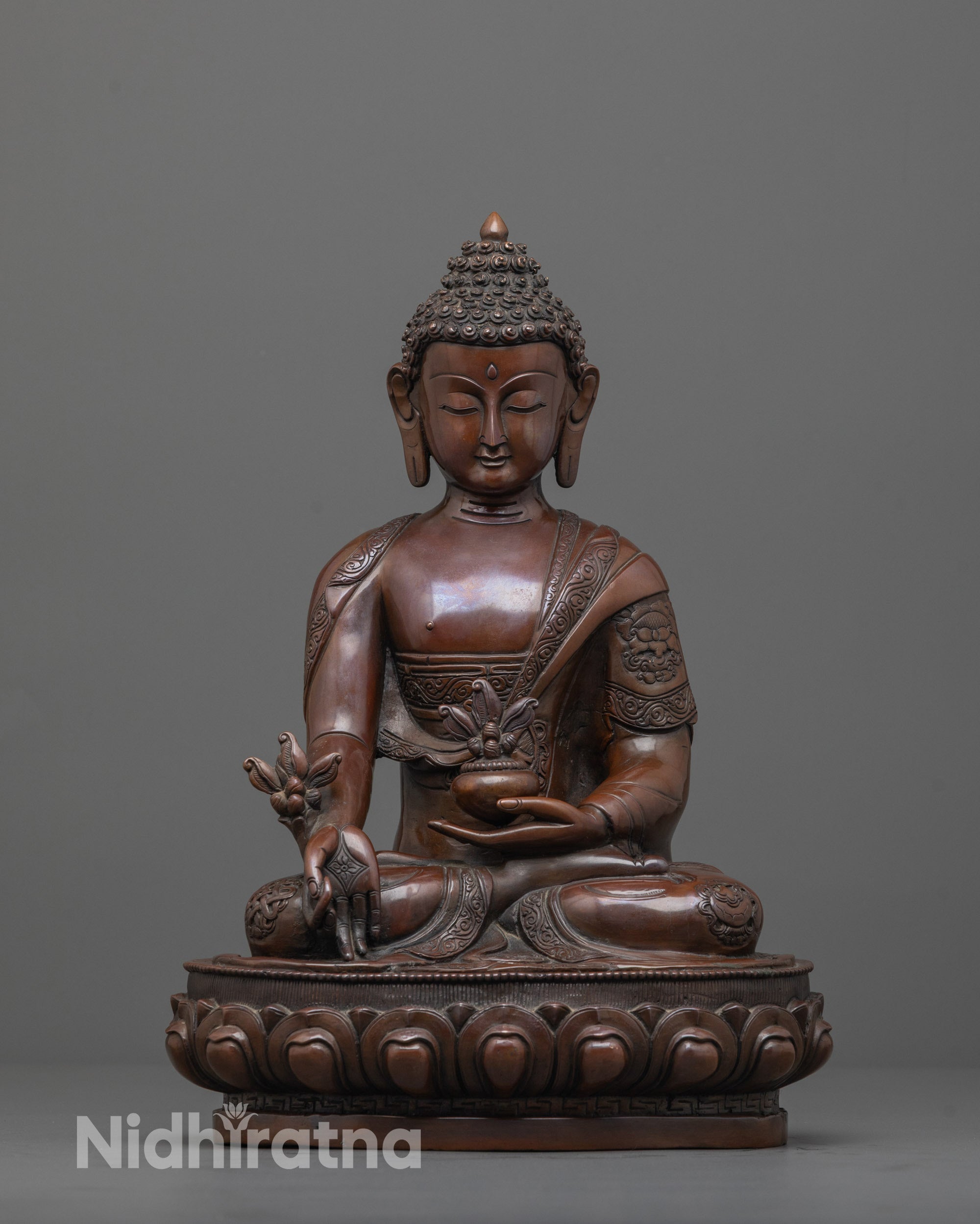 oxidized medicine buddha front view with monk robe and myrobalan in earthy copper finish