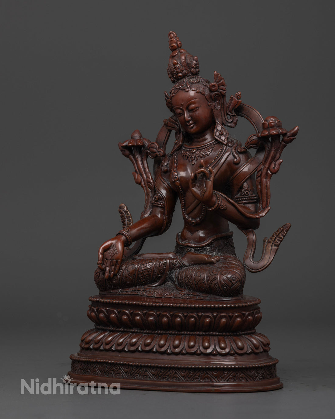 side view of oxidized white tara statue with intricate details