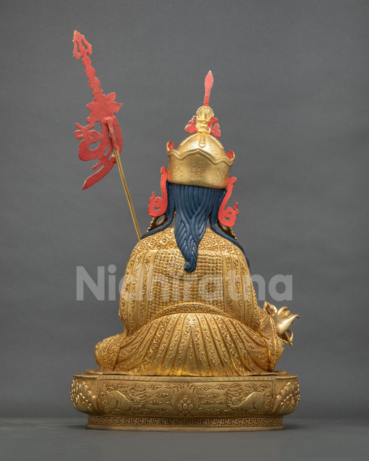 Padmasambhava statue back view, braided blue hair and cloud-scroll robe engraving, gold fire-gilded