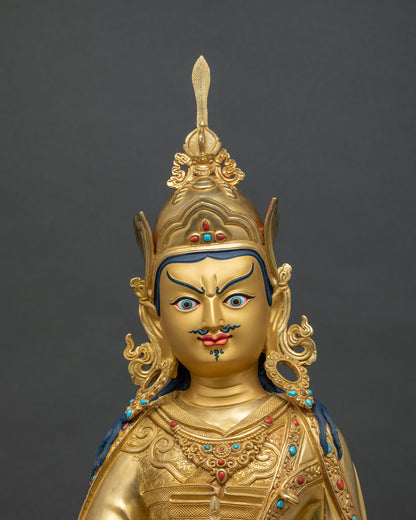 Padmasambhava statue close up, hand-chased robes and jeweled necklace in gold fire-gilded copper