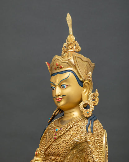 Padmasambhava statue side close up, hand-chiseled robe scrollwork and jeweled necklace, gold fire-gilded