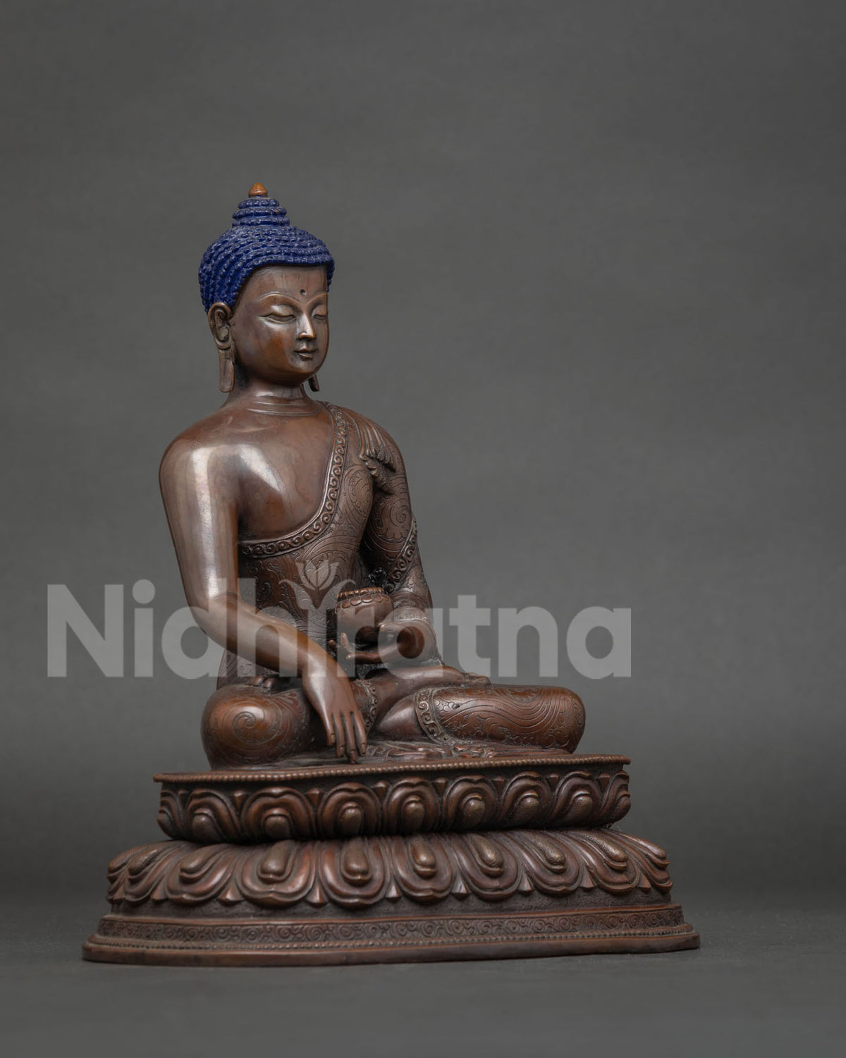 Patra alms bowl and hand carved floral motifs on the monastic robe.