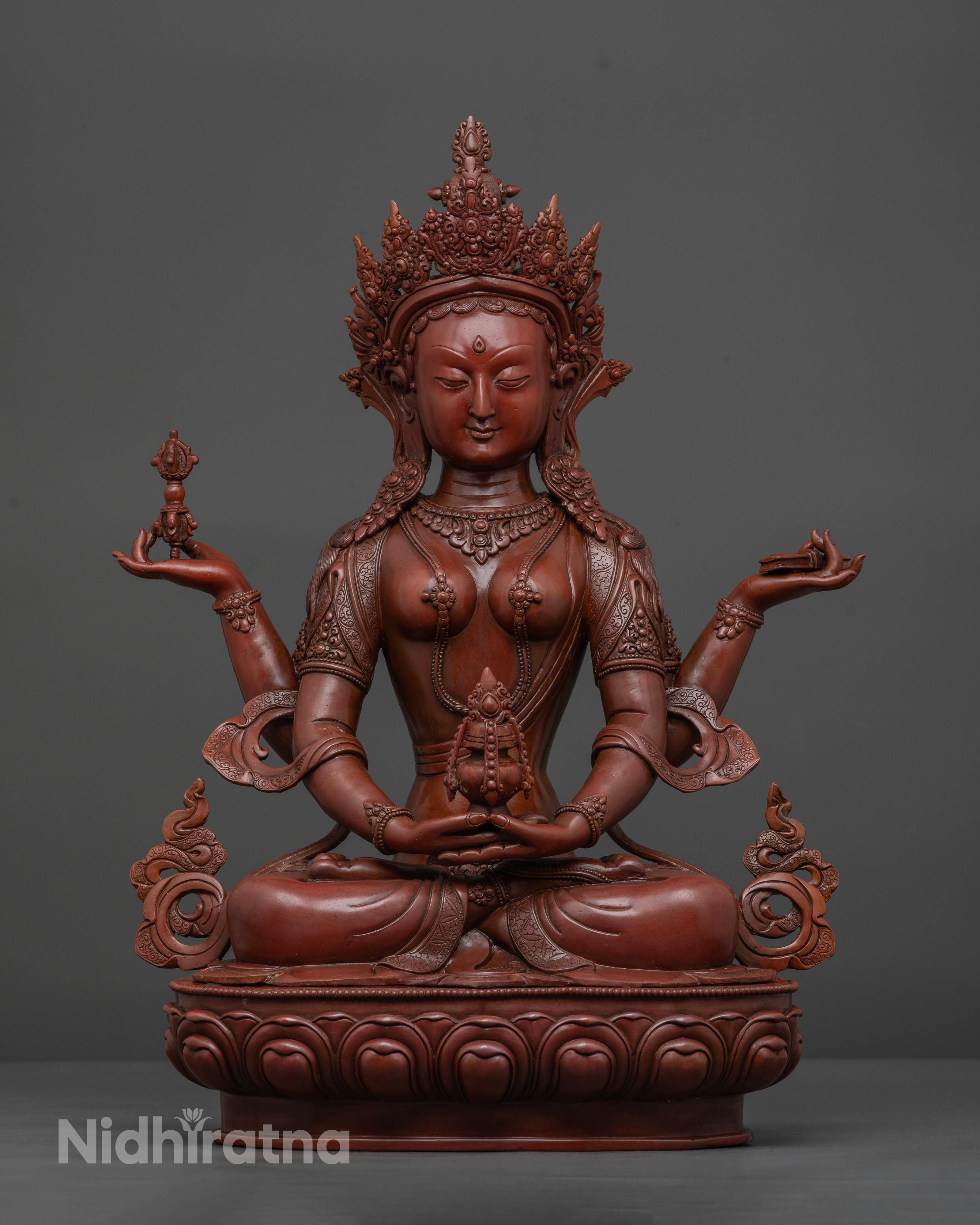 Prajnaparamita statue seated on lotus pedestal with four arms and sacred Buddhist symbols