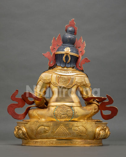 Rear back view of copper Dzambhala statue revealing lotus base carving and gold gilded finishing.