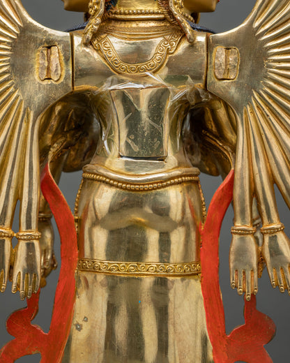 Rear detail of Chenrezig statue showing gold-gilded torso, engraved pattern and red scarf ends