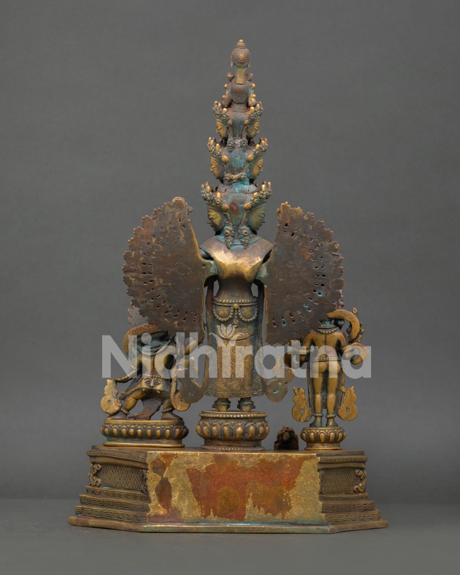 Rear view of 1000-Arm Chenrezig statue displaying halo back and pedestal base