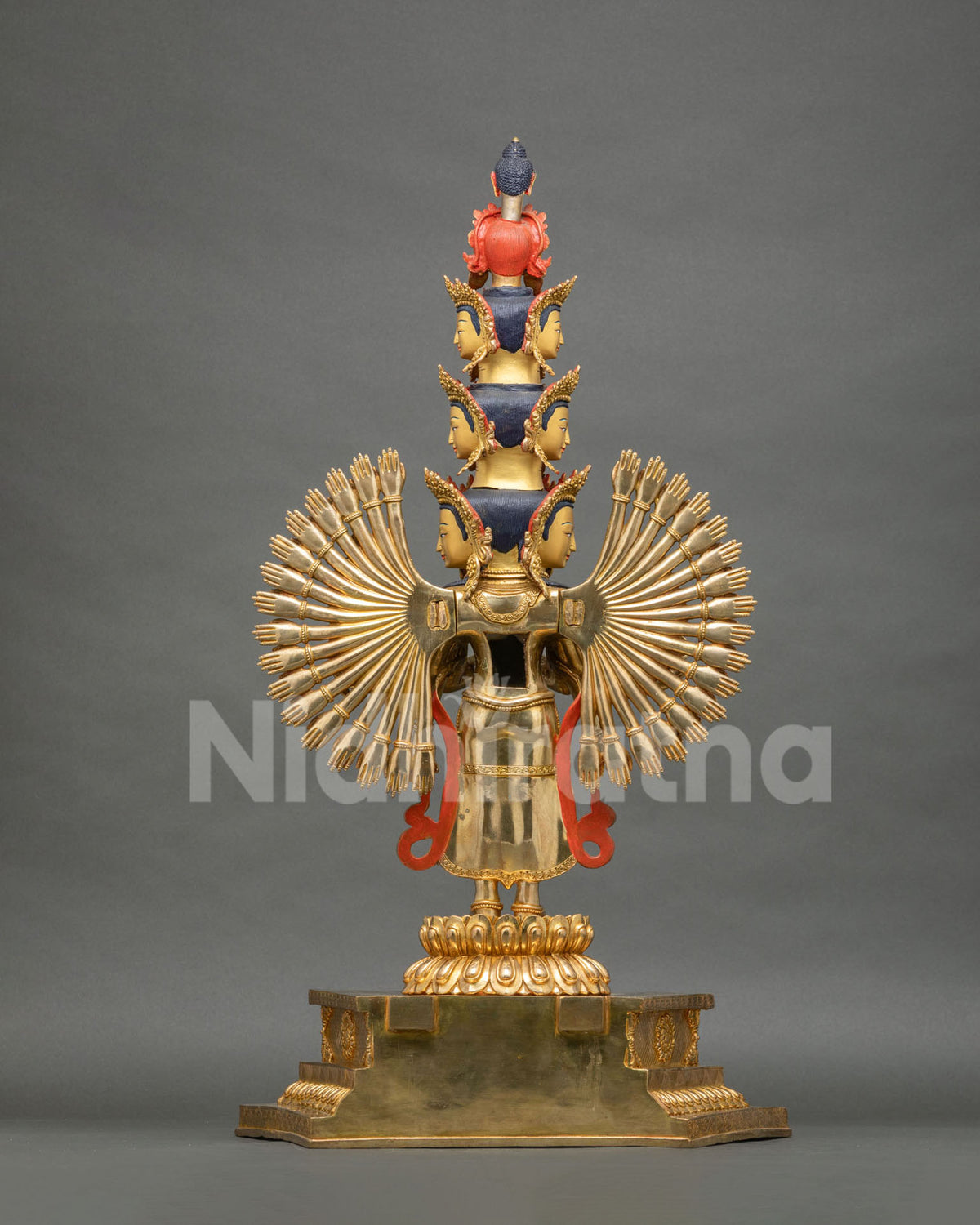 Rear view of gold-gilded 1000-armed Chenrezig statue with eleven heads and lotus pedestal
