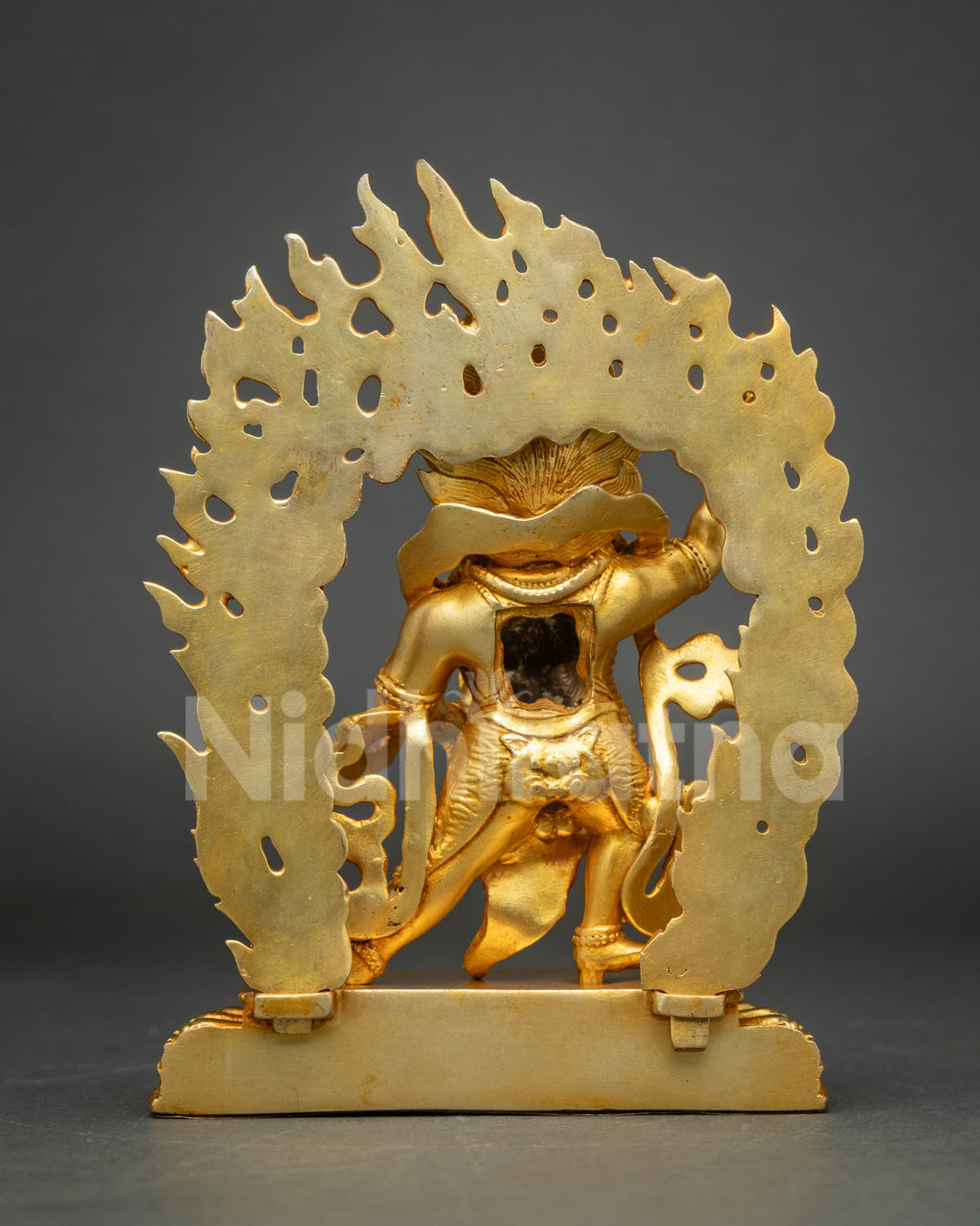Rear view of gold Vajrapani statue showing the flame backplate and detailed copper casting