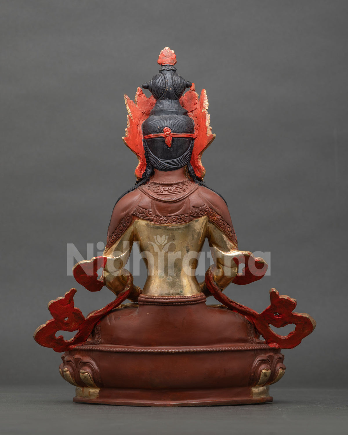 Rear view of Nepalese Amitayus statue showing partially oxidized finish and red flame halo