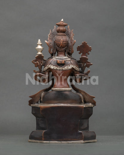 Rear view of oxidized copper Maitreya Buddha statue showing ornate finial and throne base