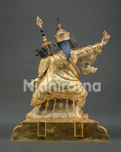 Rear view of standing Guru Rinpoche sculpture with flowing robes and khatvanga staff