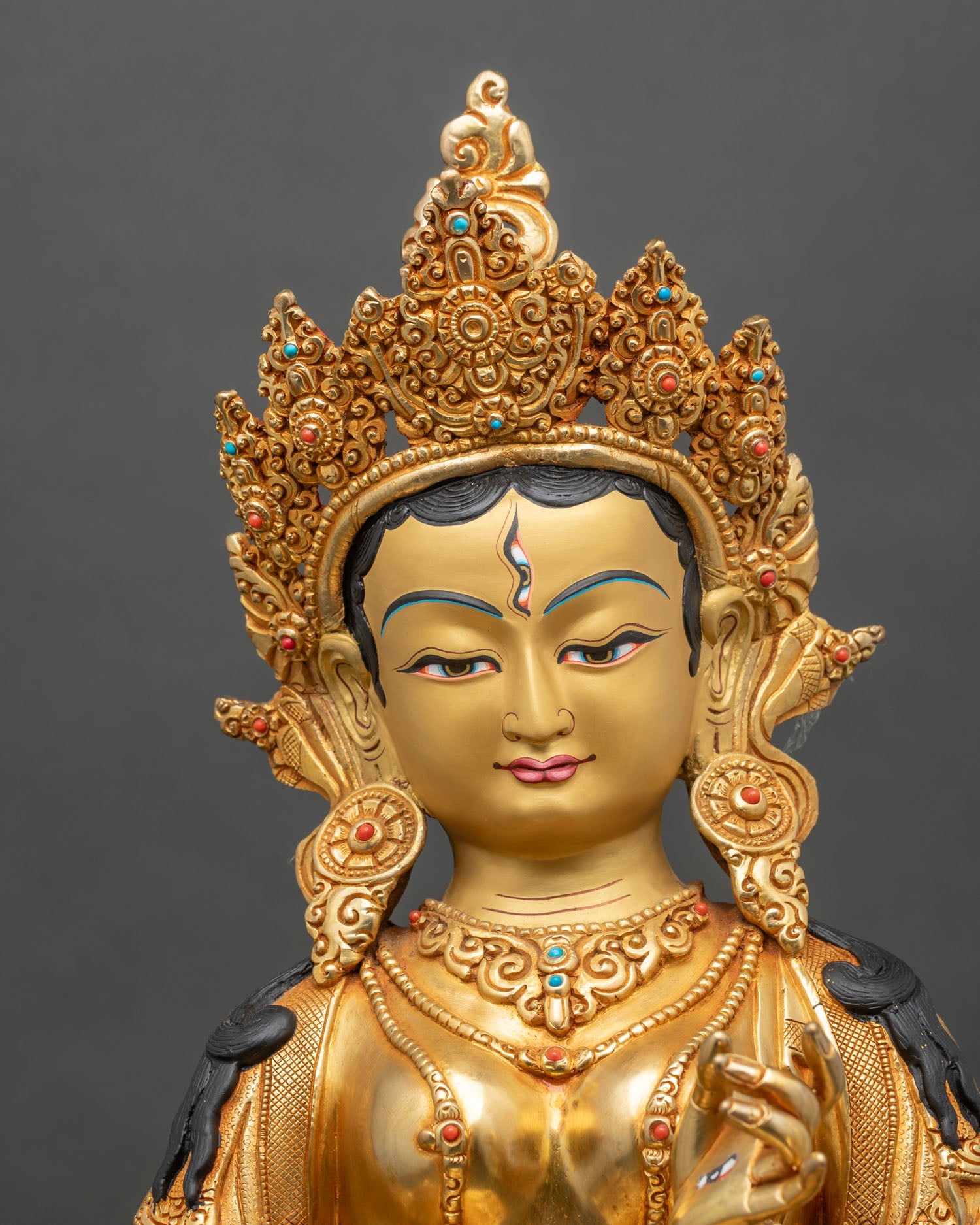 Regular close-up of Dukar statue, intricate copper sculpture with gold and vibrant colors