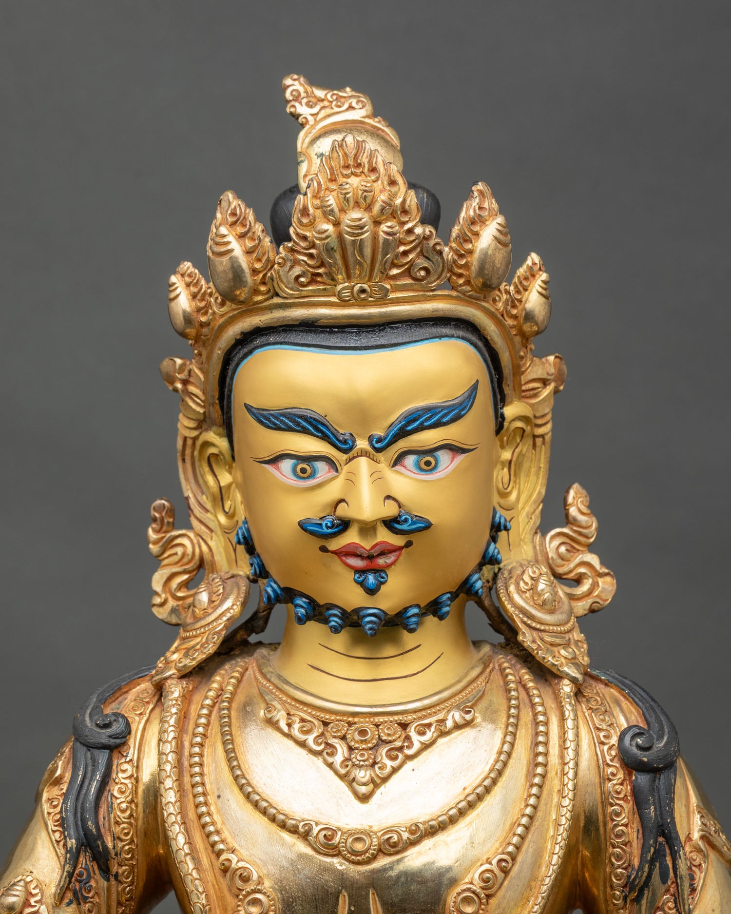Regular close-up of Dzambhala Statue showing copper and gold details, Himalayan artistry