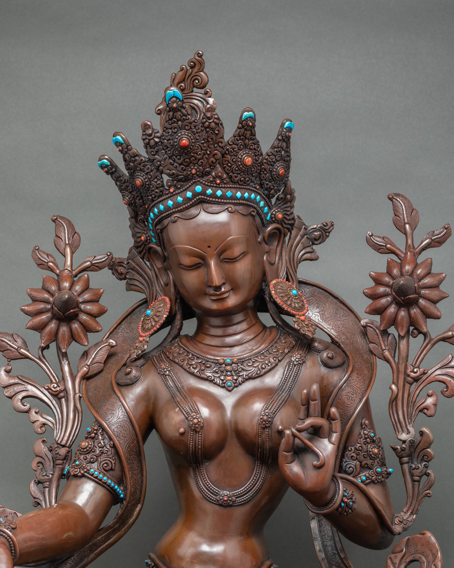 Regular close-up of Green Tara statue showing full posture and carved double-lotus pedestal