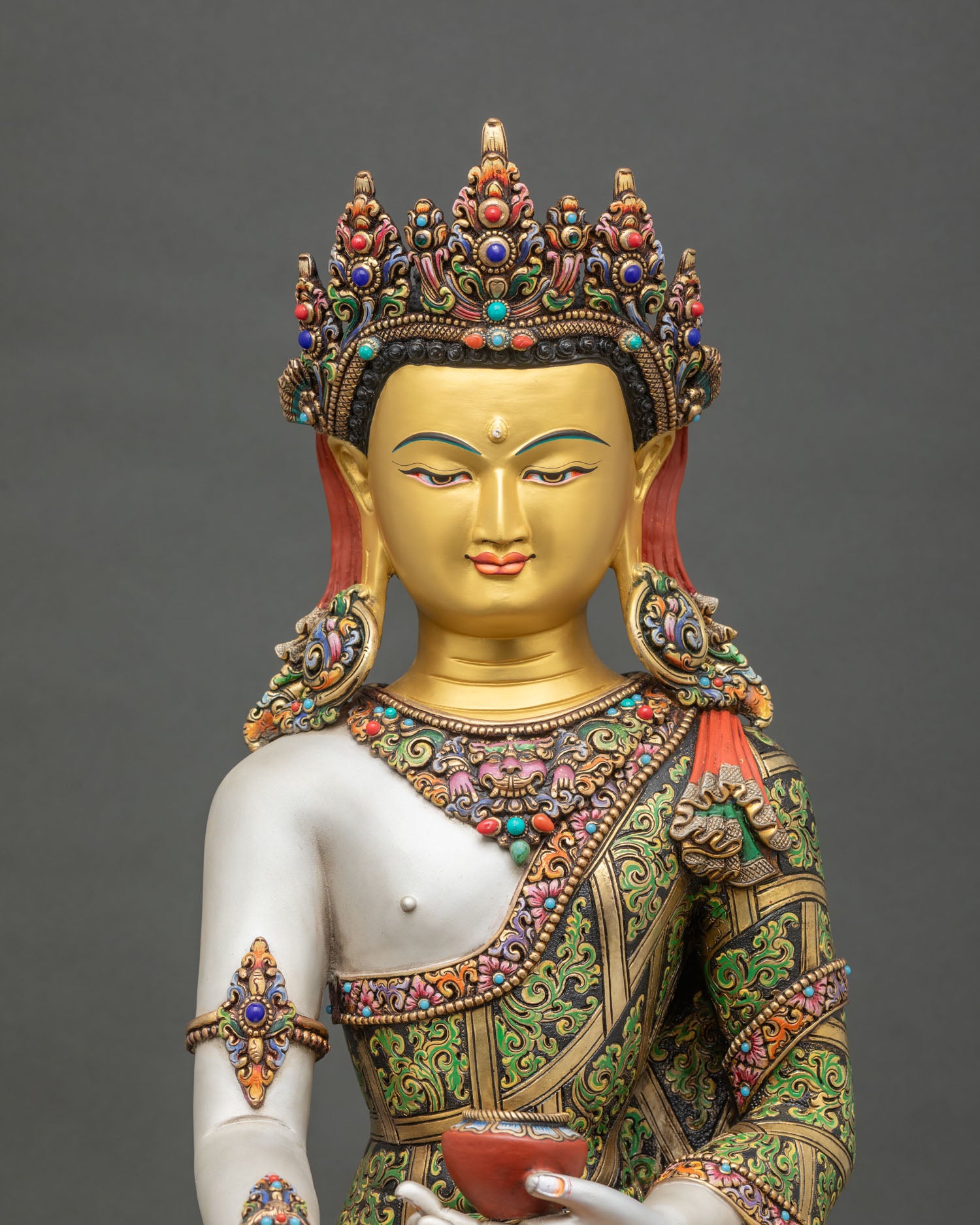 regular close up of crown shakyamuni buddha statue showing intricate gold face and robe details