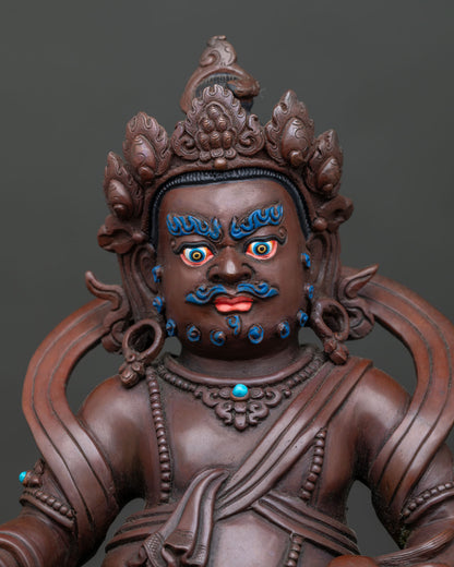 regular close up of ornate Dzambhala statue with jeweled crown and detailed copper carving