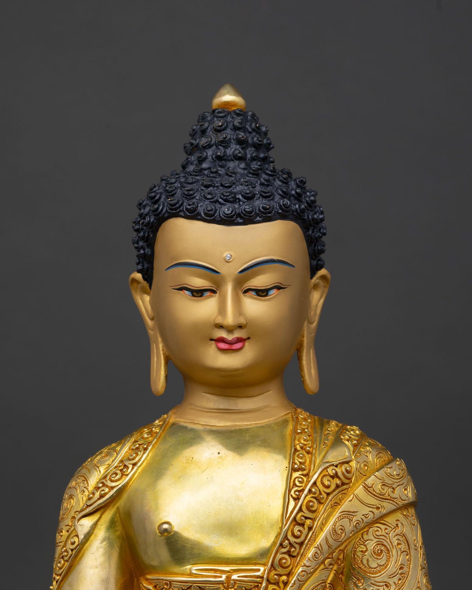 Regular close-up of Shakyamuni Buddha statue showing copper and gold detailing