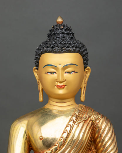 Regular close-up of Shakyamuni Buddha statue showing detailed robes and gold finish