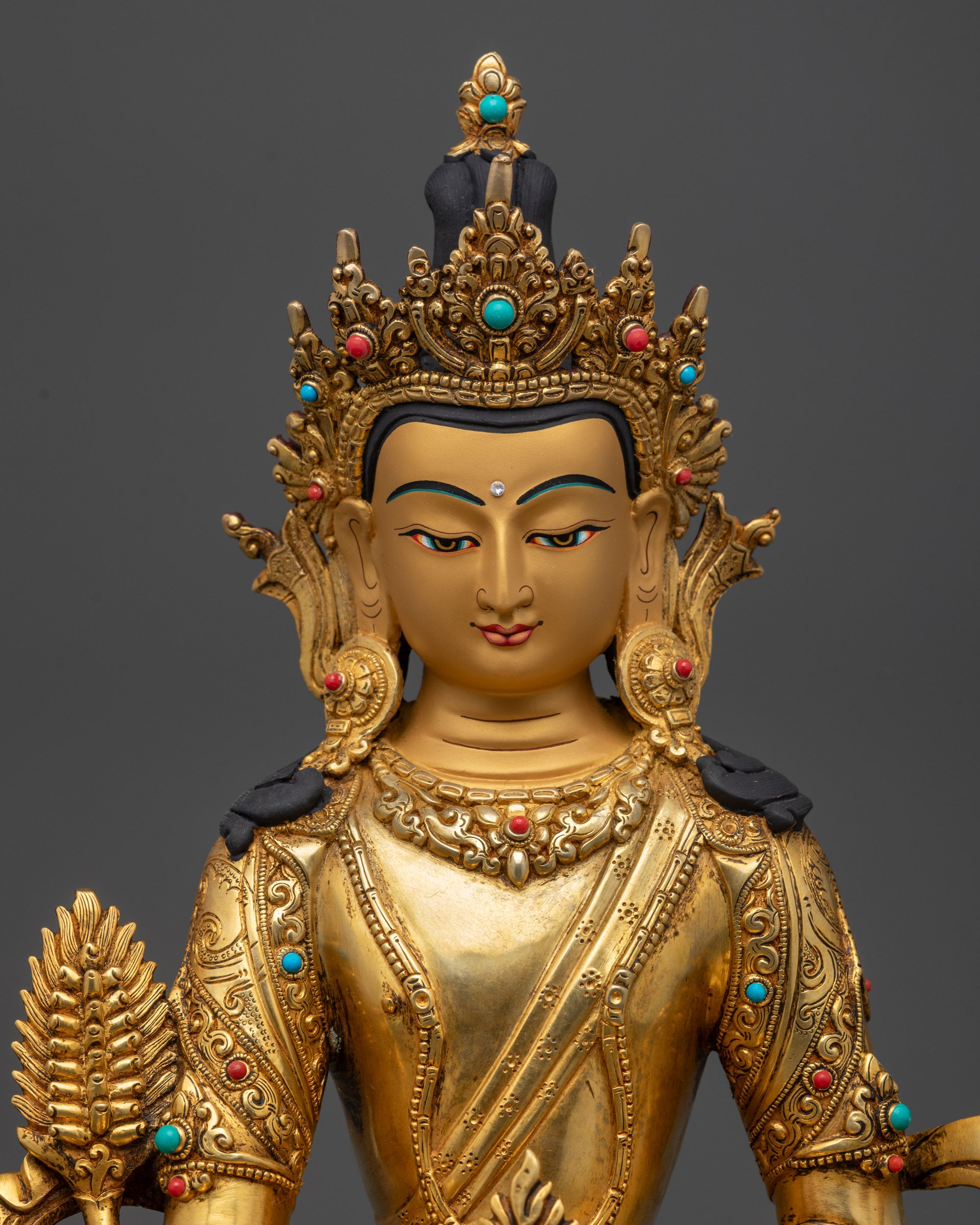 regular close up kshitigarbha statue jeweled robe and gold-gilded details
